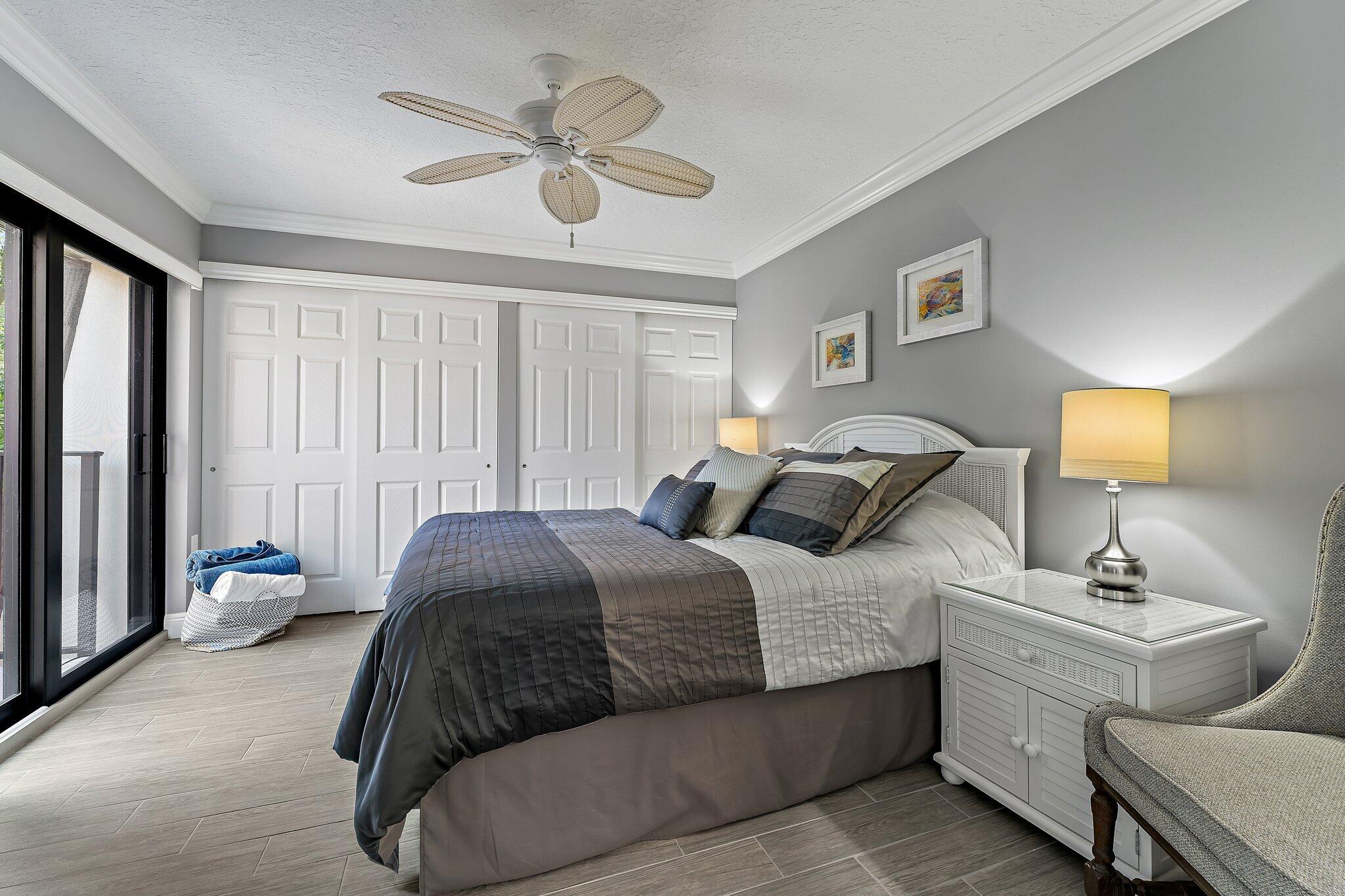 2403 24th Court Jupiter, FL 33477 - Photo 24 of 29 a bedroom with a bed and a chandelier