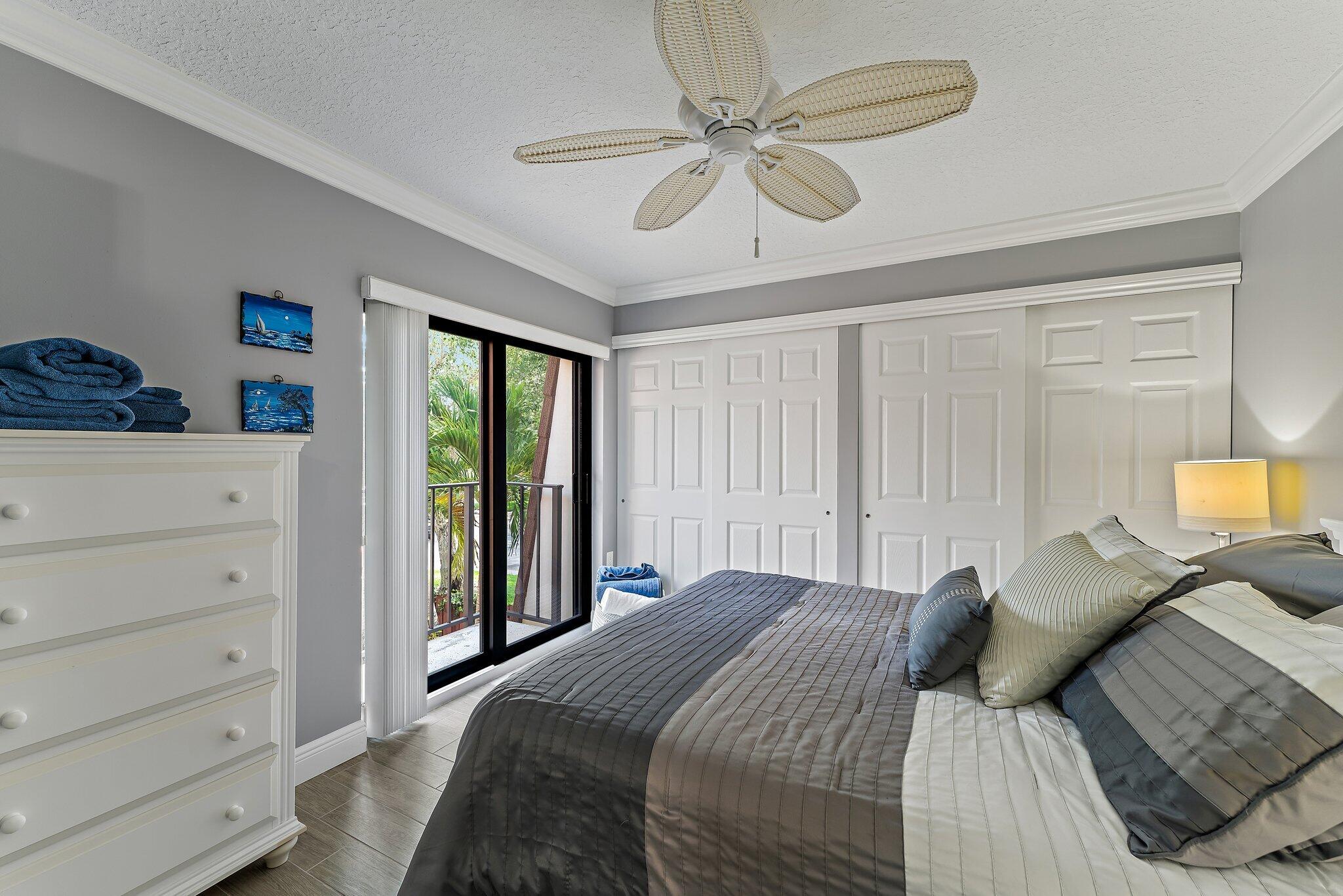 2403 24th Court Jupiter, FL 33477 - Photo 25 of 29 a bedroom with a large bed and a chandelier