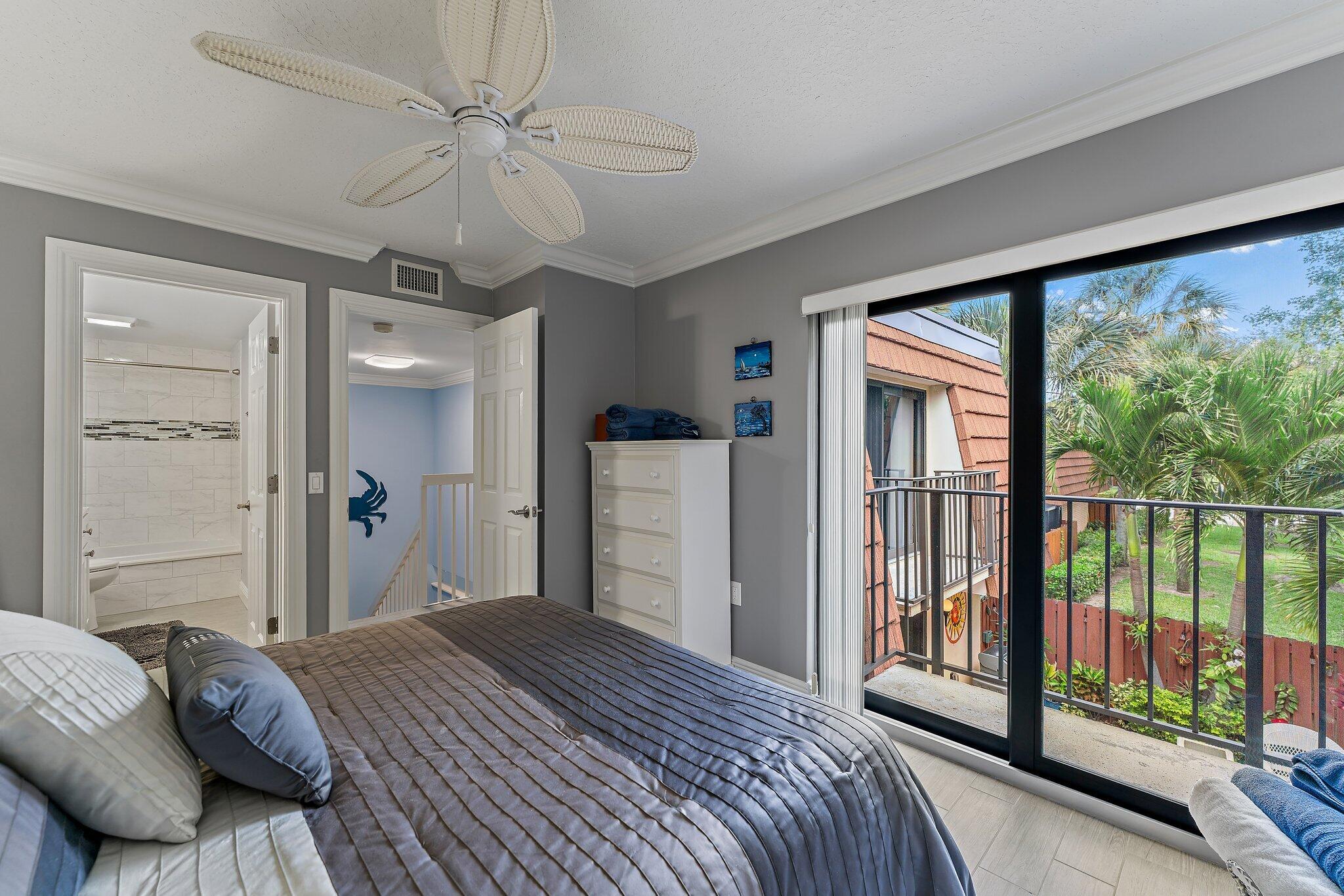 2403 24th Court Jupiter, FL 33477 - Photo 26 of 29 a bedroom with a large bed and a large window