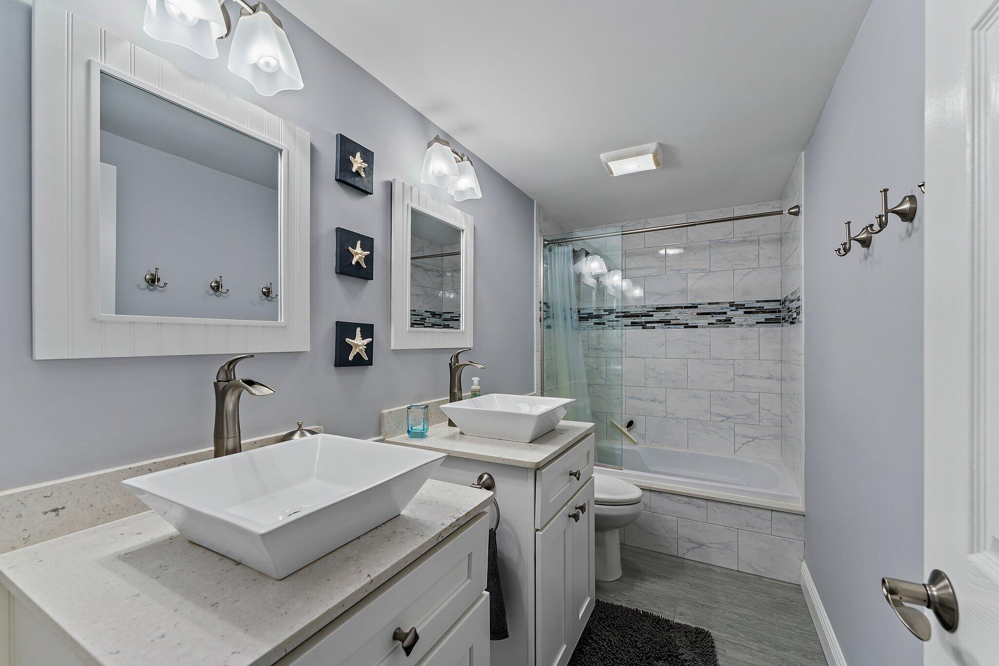 2403 24th Court Jupiter, FL 33477 - Photo 27 of 29 a bathroom with a sink toilet a mirror and shower