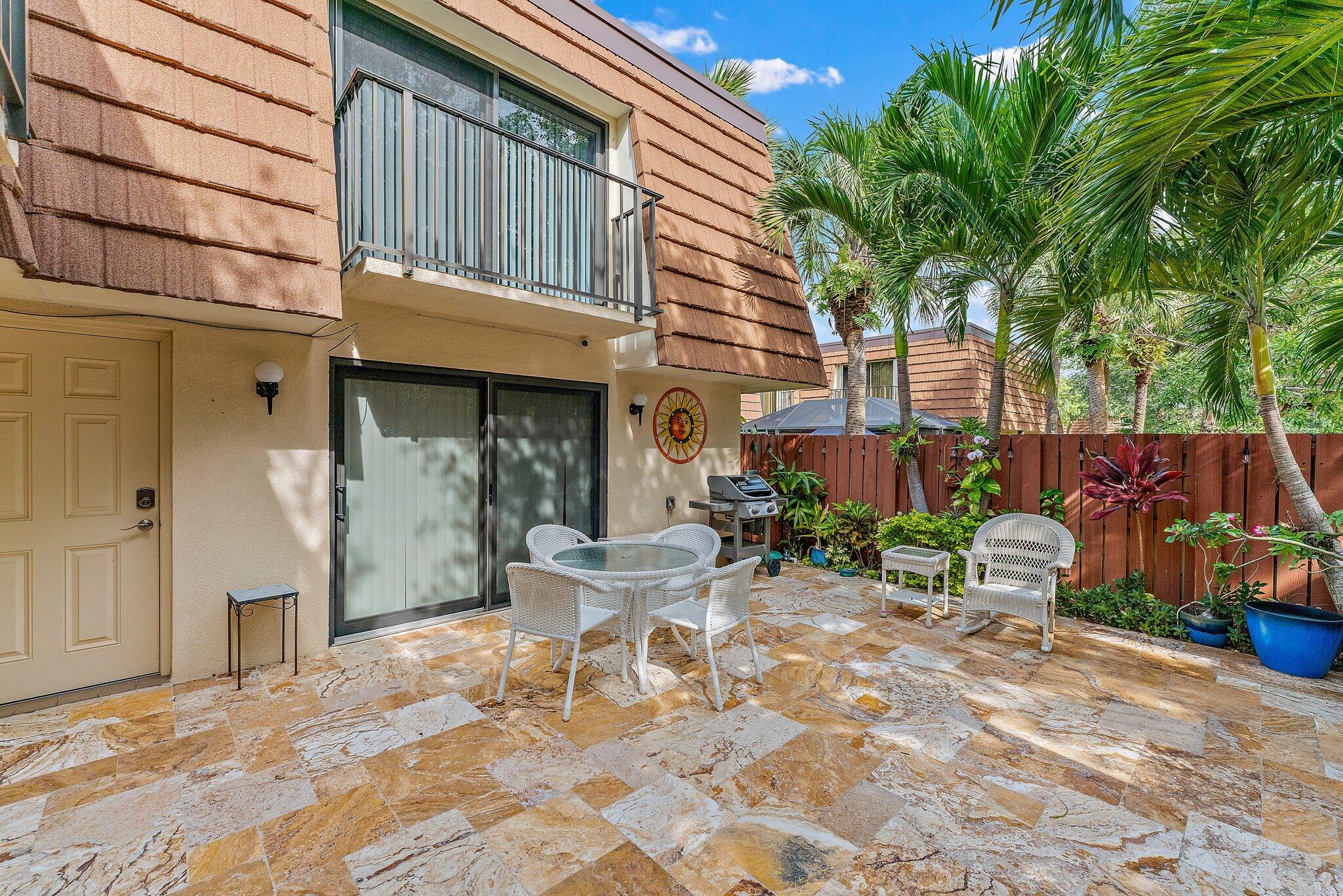 2403 24th Court Jupiter, FL 33477 - Photo 5 of 29 a view of a chairs and table in backyard of the house