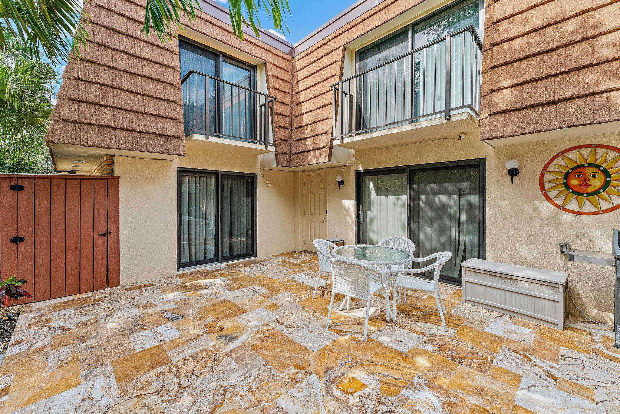 2403 24th Court Jupiter, FL 33477 - Photo 6 of 29 a patio with a table and chairs