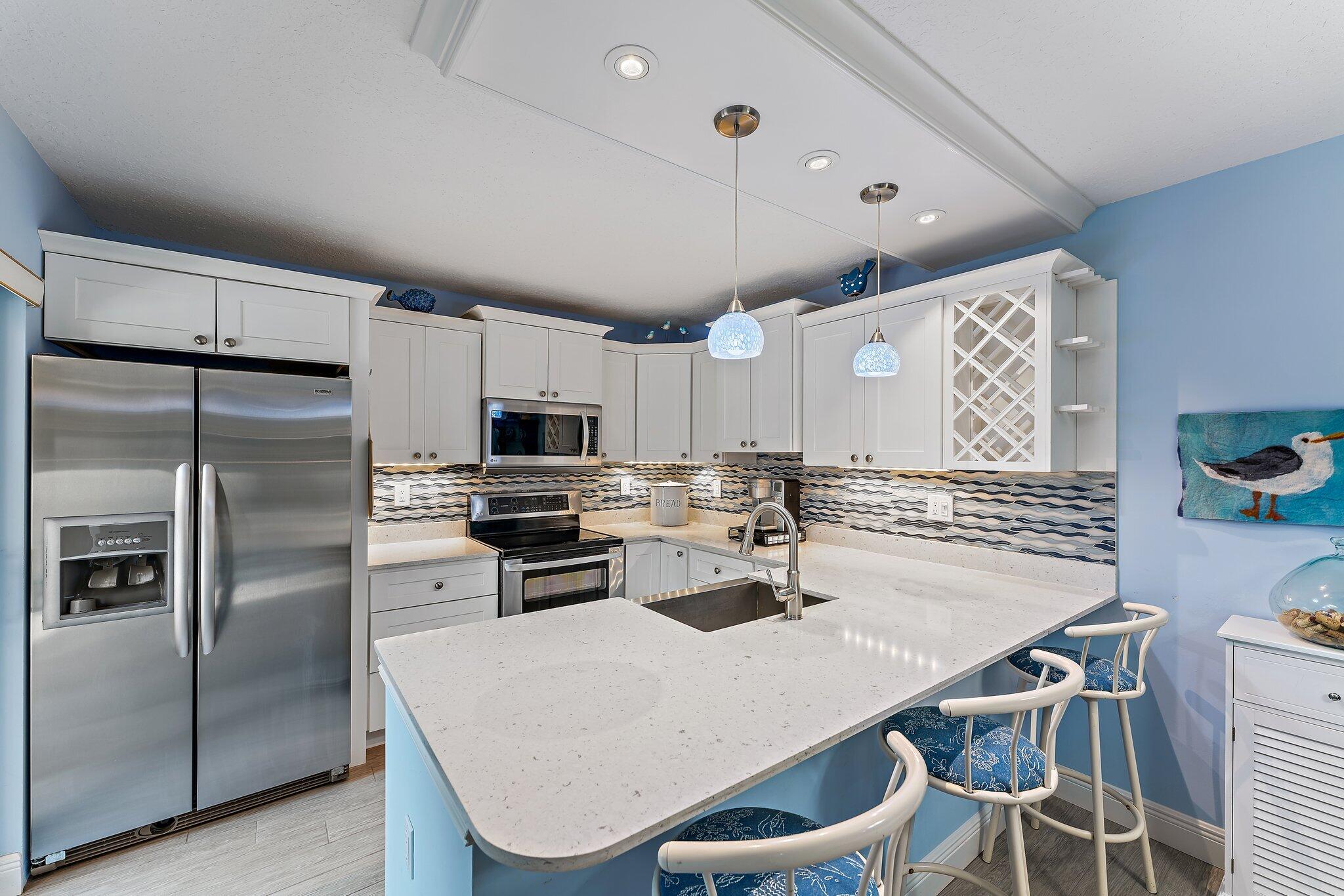 2403 24th Court Jupiter, FL 33477 - Photo 7 of 29 a kitchen with a dining table chairs and refrigerator
