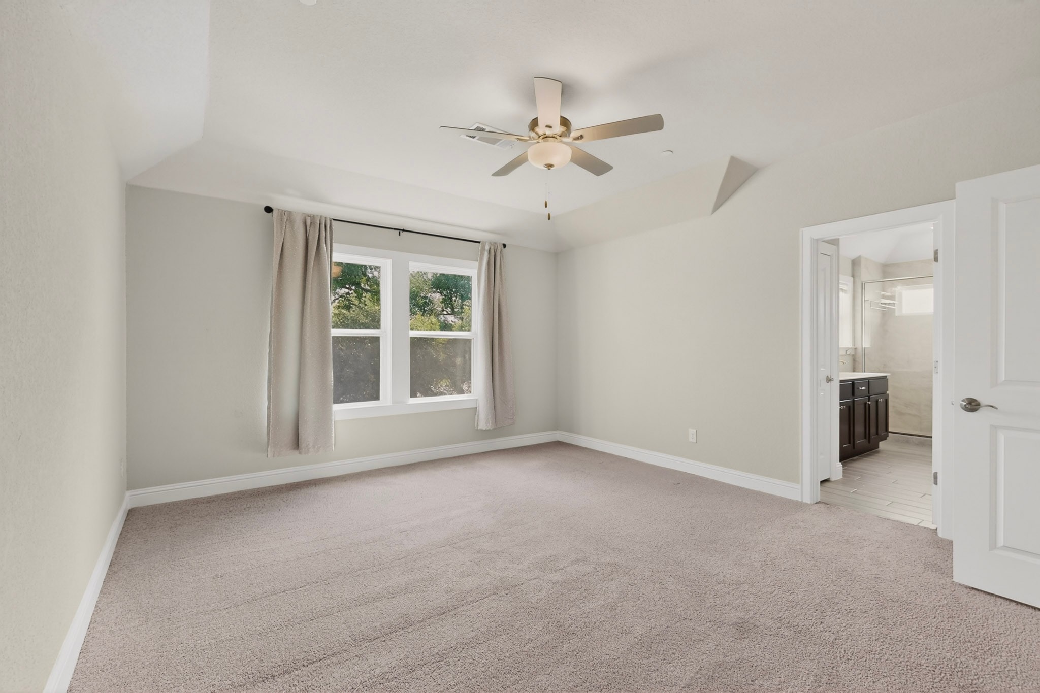 2605 Sam Bass Road, Unit 9 Round Rock, TX 78681 - Photo 22 of 38 A spacious primary bedroom features soft carpet flooring, abundant natural light, and convenient access to the primary bathroom.