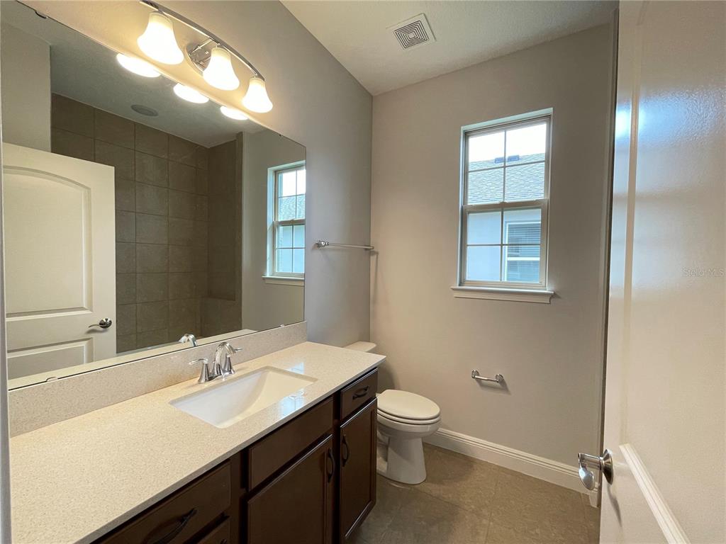 3434 Sagebrush Street Harmony, FL 34773 - Photo 11 of 21 a bathroom with a toilet sink and mirror