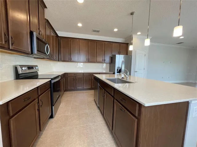 a kitchen with a sink a center island and wooden floor