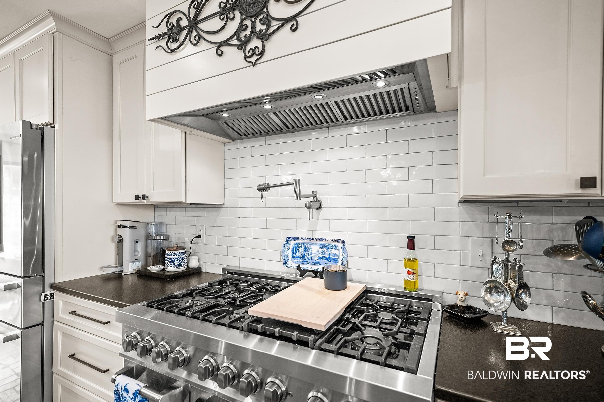 8490 Bay View Drive Foley, AL 36535 - Photo 23 of 67 Kitchen with custom exhaust hood, appliances with stainless steel finishes, white cabinetry, and tasteful backsplash