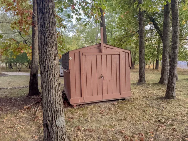 a backyard of a house with wooden fence and large trees