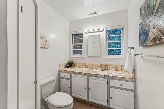 a bathroom with a sink toilet vanity and window