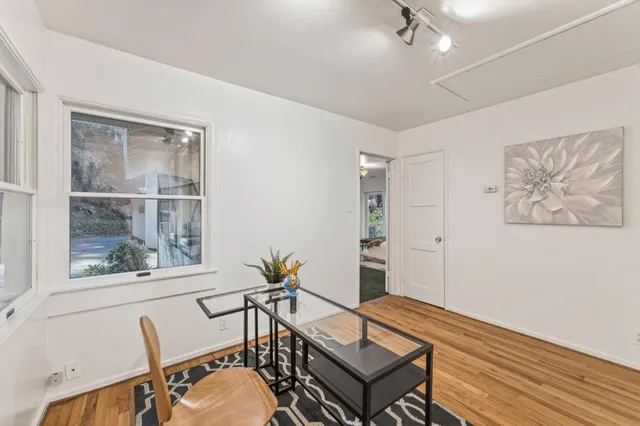 a view of a workspace with furniture and a window