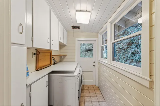 a utility room with cabinets washer and dryer