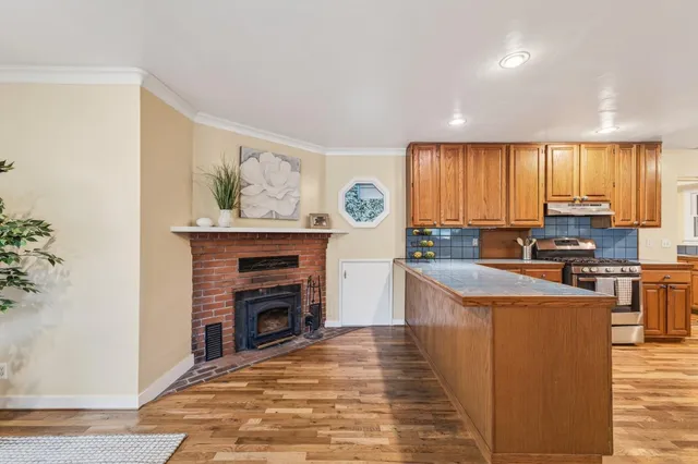 a kitchen with granite countertop a stove top oven sink and cabinets