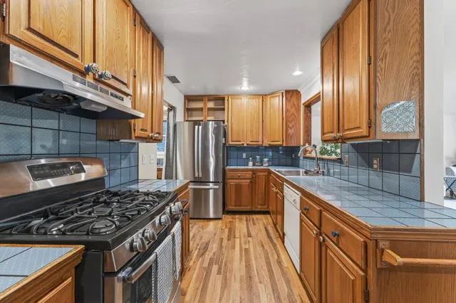 a kitchen with stainless steel appliances granite countertop a stove a sink dishwasher and refrigerator