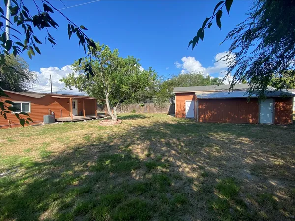an empty room with kitchen view and a fireplace