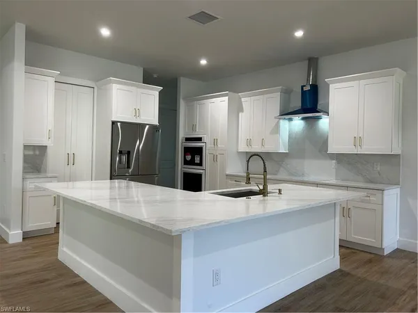 a kitchen with kitchen island a sink stove and refrigerator