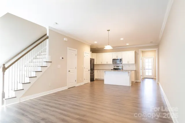 a view of kitchen with kitchen island sink refrigerator and window