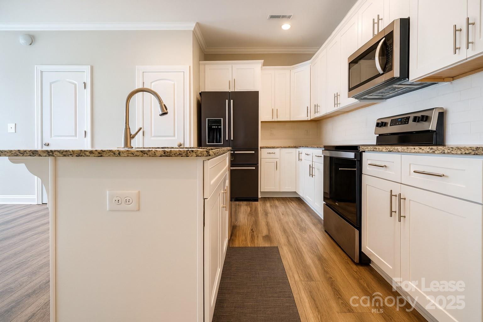 2180 Moss Meadow Lane Denver, NC 28037 - Photo 6 of 20 a kitchen with stainless steel appliances granite countertop a stove top oven a sink dishwasher and white refrigerator with wooden floor