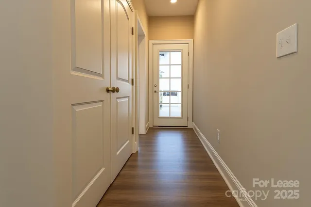 a view of a hallway with wooden floor and a window