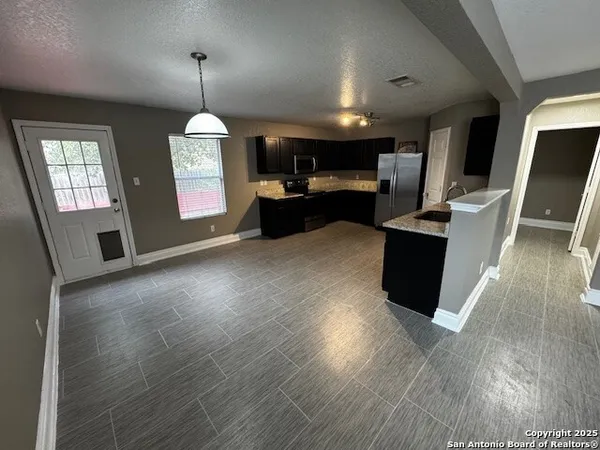 a open kitchen with cabinets a stove and a wooden floors