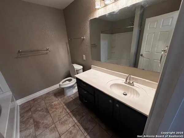 a bathroom with a double vanity sink toilet and mirror