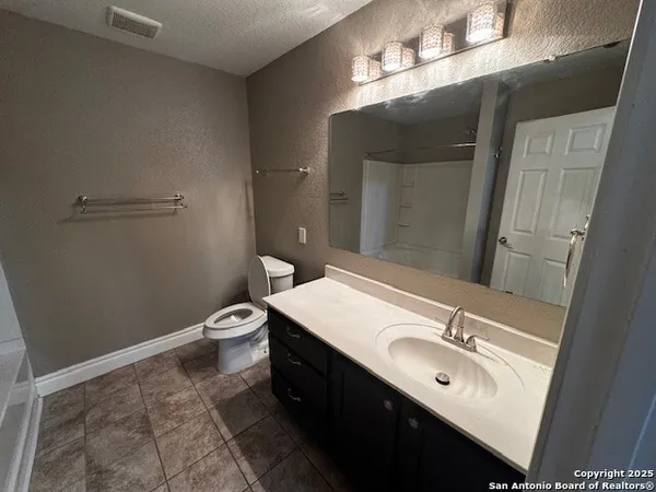 a bathroom with a sink a toilet and mirror