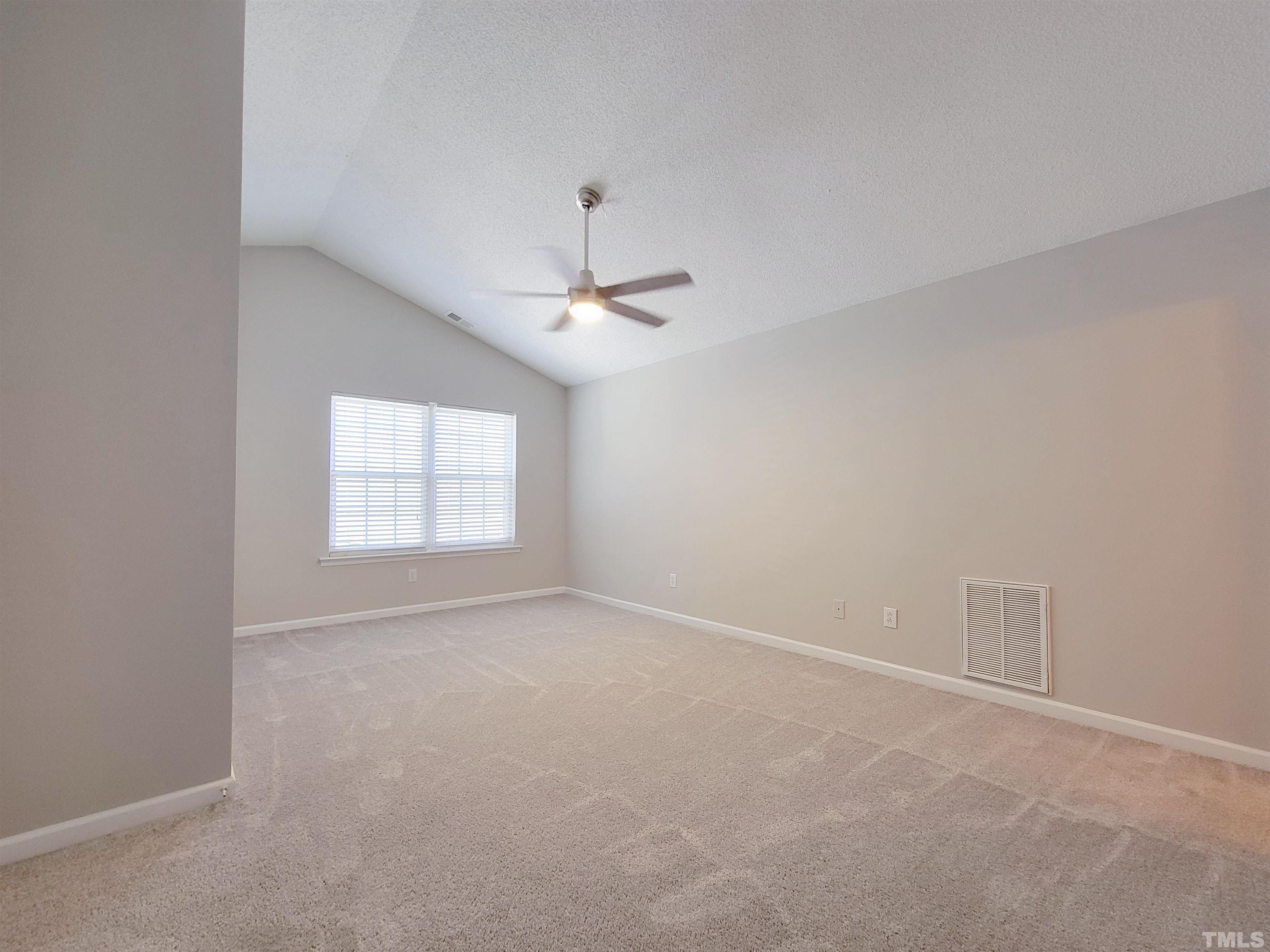 3240 Marcony Way Raleigh, NC 27610 - Photo 9 of 31 an empty room with a chandelier fan and windows
