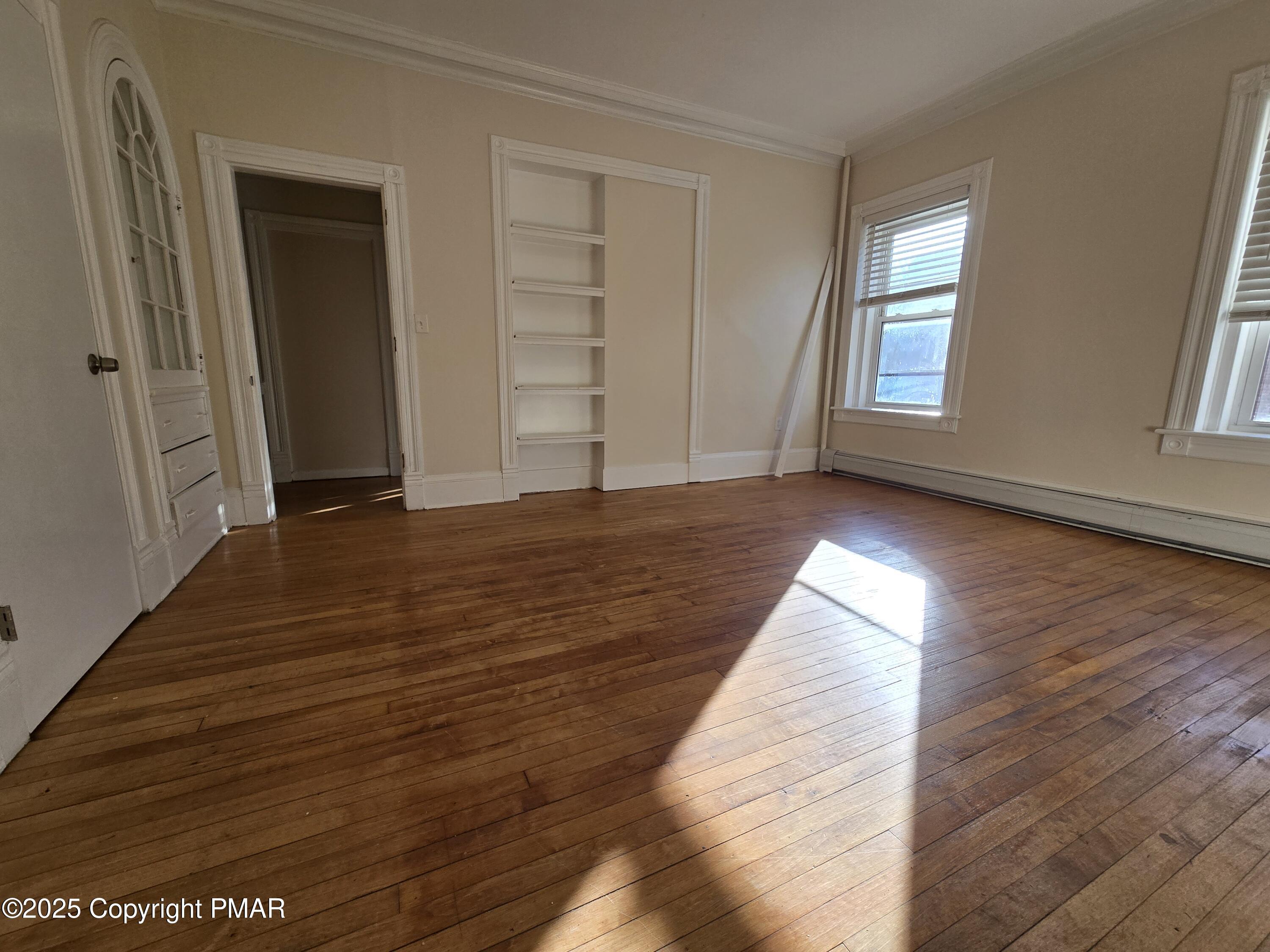 584 Main Street, Unit 1 Stroudsburg, PA 18360 - Photo 9 of 17 an empty room with wooden floor and windows