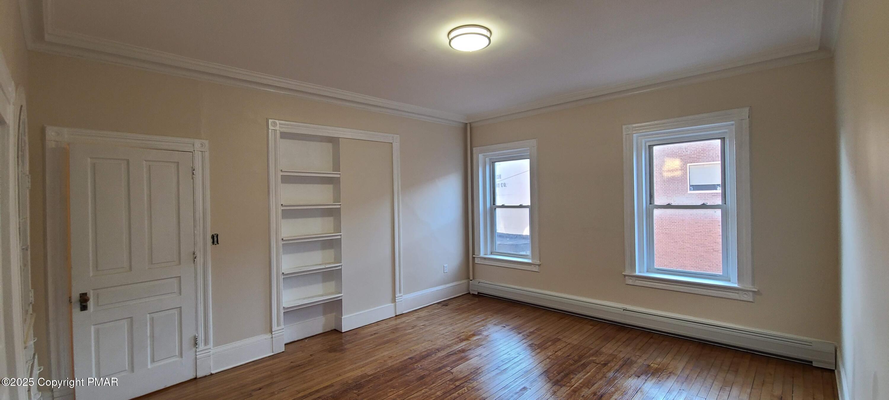 584 Main Street, Unit 1 Stroudsburg, PA 18360 - Photo 10 of 17 an empty room with wooden floor closet and windows