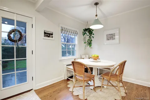 a dining room with wooden floor and a chandelier
