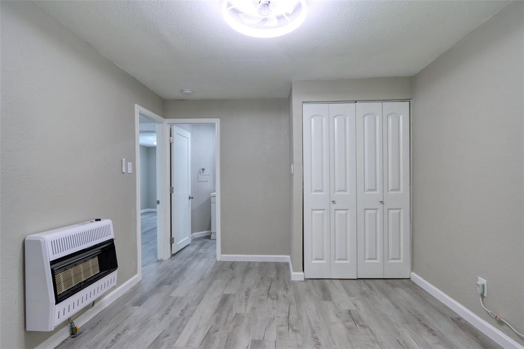 311 West McKinney Street Pilot Point, TX 76258 - Photo 11 of 33 The room features light gray walls, a light wood-style floor, and a bi-fold closet