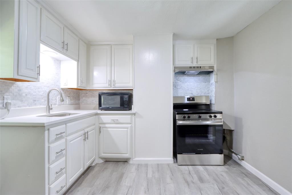 311 West McKinney Street Pilot Point, TX 76258 - Photo 20 of 33 Kitchen featuring white cabinetry, light-colored countertops, a stainless steel range, and a tiled backsplash