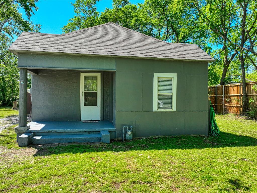 311 West McKinney Street Pilot Point, TX 76258 - Photo 2 of 33 The property features an exterior painted in a modern gray tone with white trim, a covered porch with supporting columns, and a front yard with a well-maintained lawn