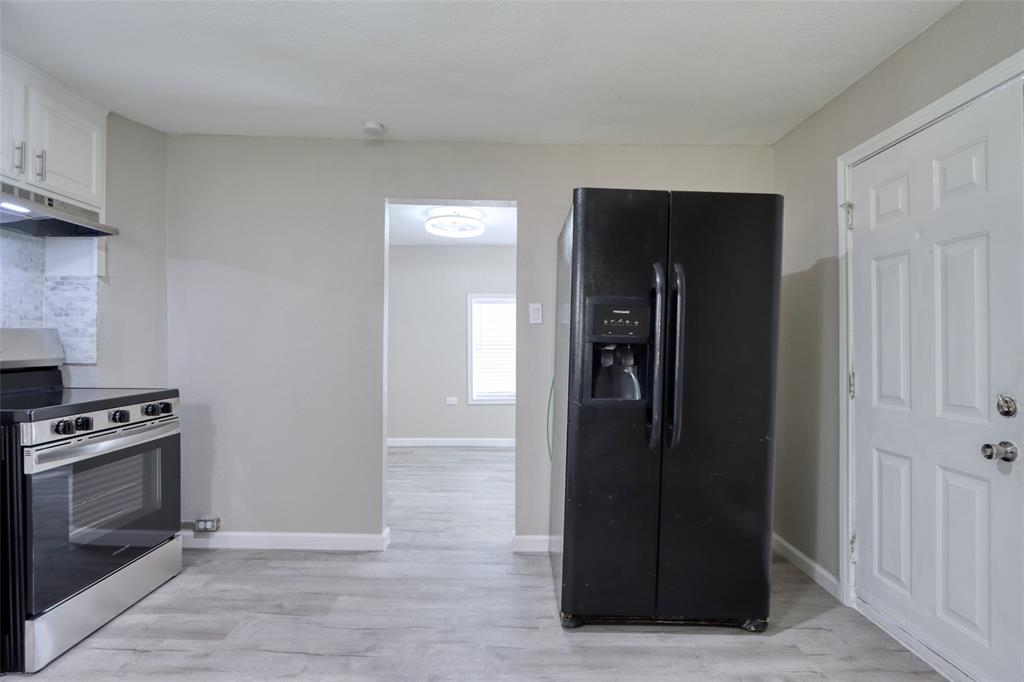 311 West McKinney Street Pilot Point, TX 76258 - Photo 24 of 33 The kitchen features light-toned flooring, light-colored walls, and a stainless steel oven with a black cooktop
