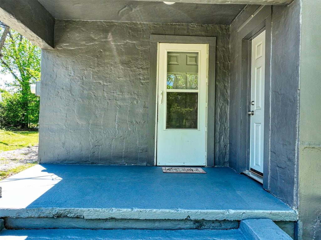 311 West McKinney Street Pilot Point, TX 76258 - Photo 3 of 33 The property features a porch with a blue painted floor and grey textured walls