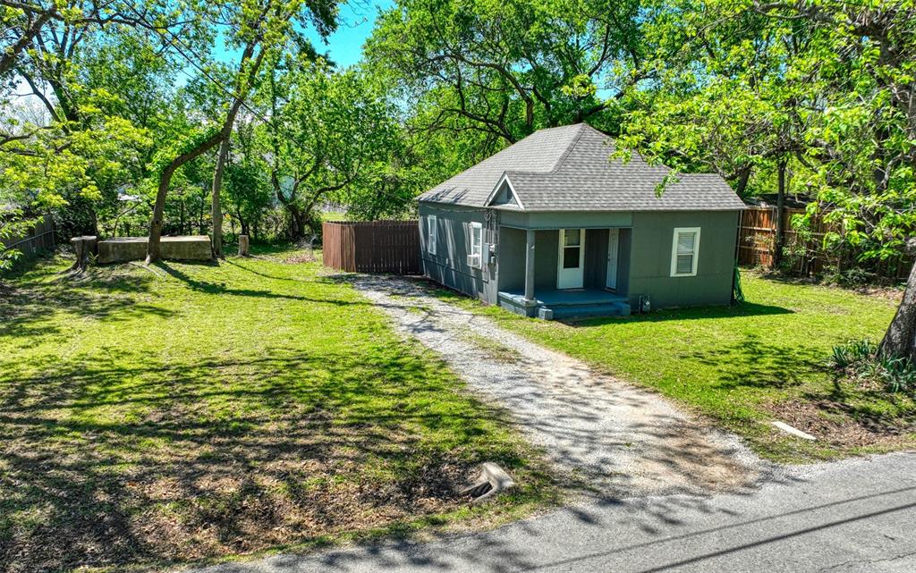 311 West McKinney Street Pilot Point, TX 76258 - Photo 31 of 33 The property features a grey exterior, a front porch, and a gravel driveway
