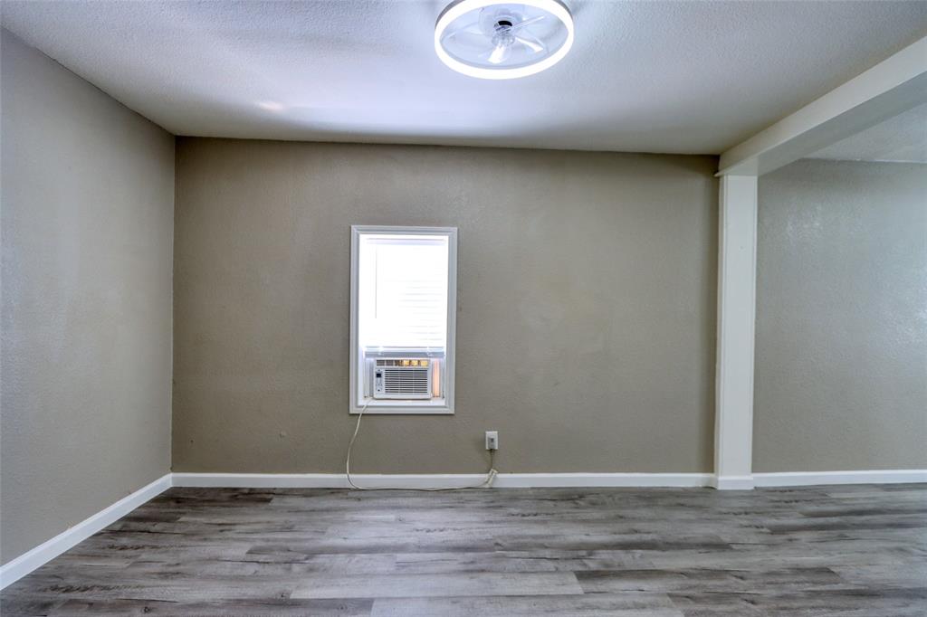 311 West McKinney Street Pilot Point, TX 76258 - Photo 6 of 33 The room features wood-look flooring, neutral-toned walls, and a window with blinds