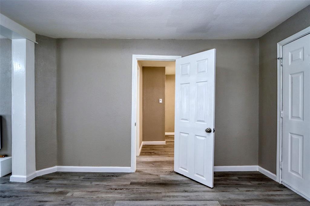 311 West McKinney Street Pilot Point, TX 76258 - Photo 7 of 33 This space features light gray walls, white trim, and wood-look flooring