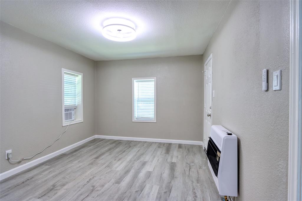 311 West McKinney Street Pilot Point, TX 76258 - Photo 8 of 33 This room features light-colored walls and wood-look flooring, creating a bright and inviting atmosphere