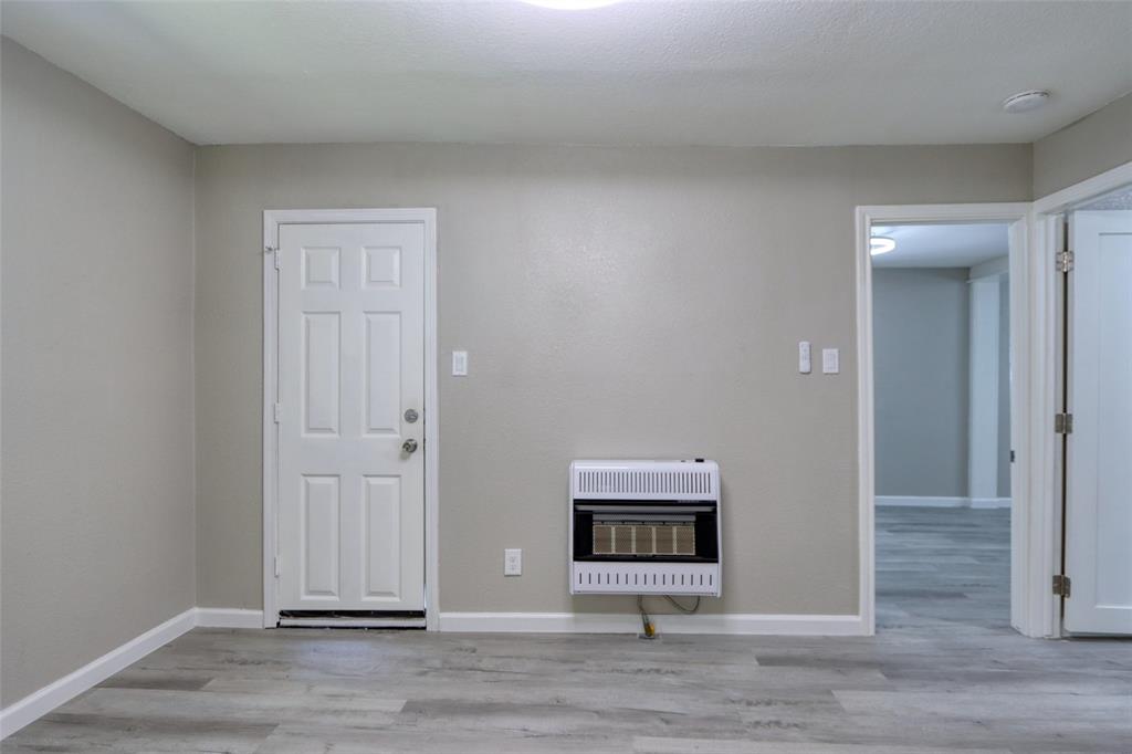 311 West McKinney Street Pilot Point, TX 76258 - Photo 10 of 33 The property features light gray walls, a white paneled door, and wood-look flooring