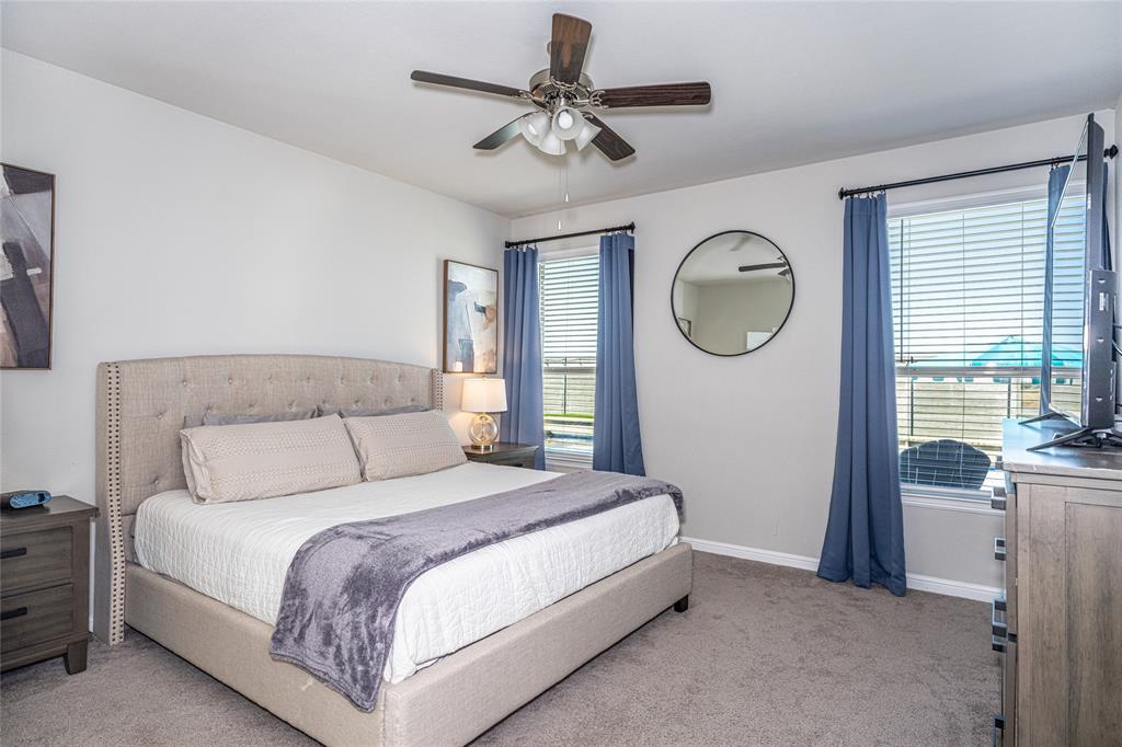 2404 Blackrail Court Argyle, TX 76226 - Photo 13 of 40 a bedroom with a large bed and a chandelier