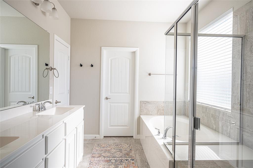 2404 Blackrail Court Argyle, TX 76226 - Photo 14 of 40 a bathroom with a tub sink and mirror