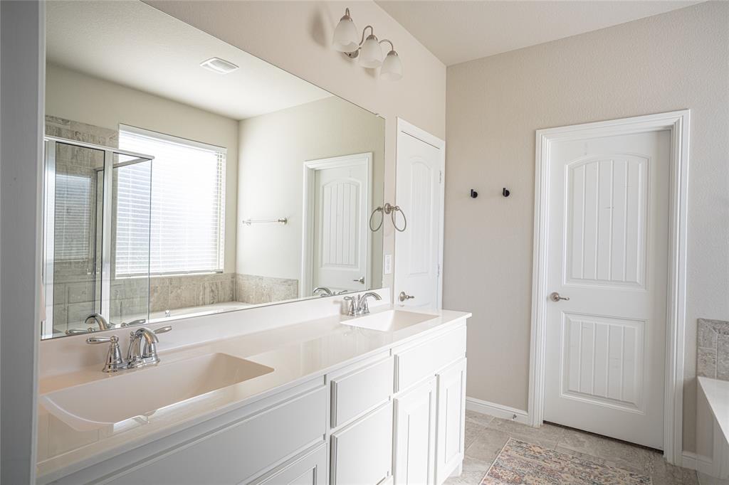 2404 Blackrail Court Argyle, TX 76226 - Photo 15 of 40 a bathroom with double vanity sinks and a mirror