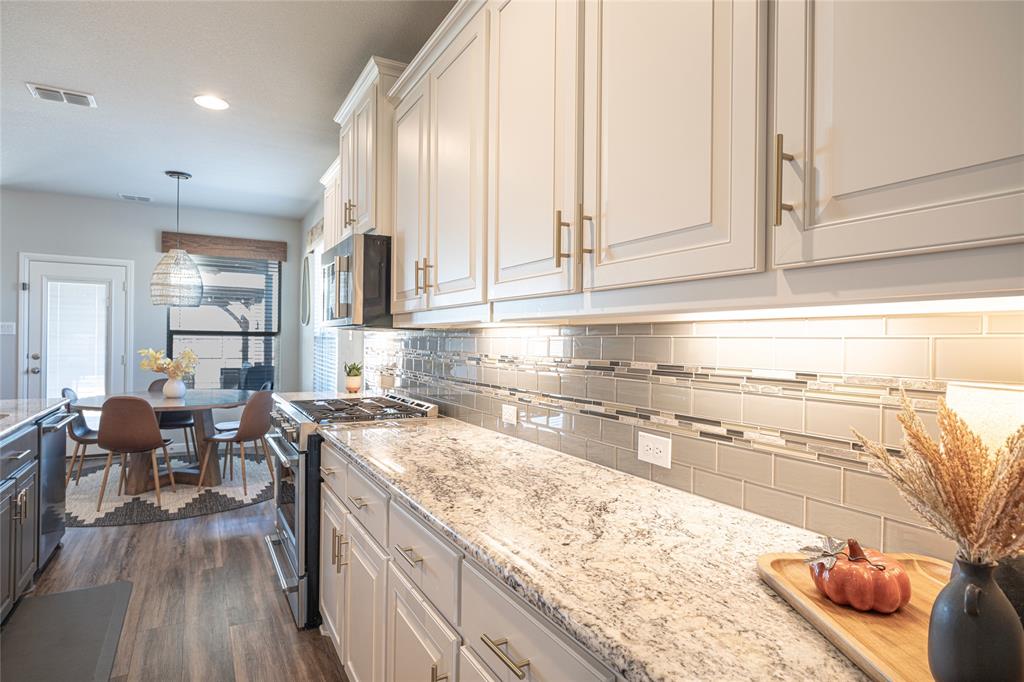 2404 Blackrail Court Argyle, TX 76226 - Photo 7 of 40 a kitchen with stainless steel appliances granite countertop a sink and cabinets