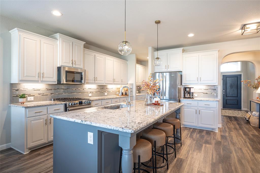 2404 Blackrail Court Argyle, TX 76226 - Photo 8 of 40 a kitchen with stainless steel appliances granite countertop a stove refrigerator sink and cabinets