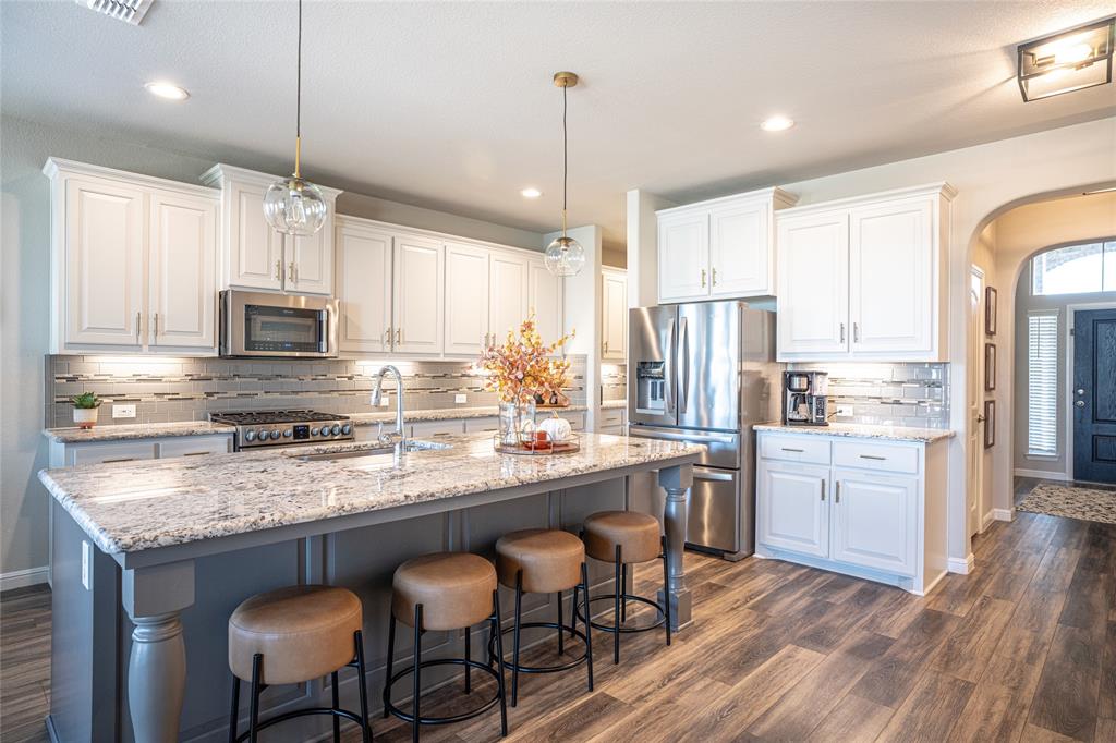 2404 Blackrail Court Argyle, TX 76226 - Photo 9 of 40 a kitchen with stainless steel appliances granite countertop a stove refrigerator sink and microwave