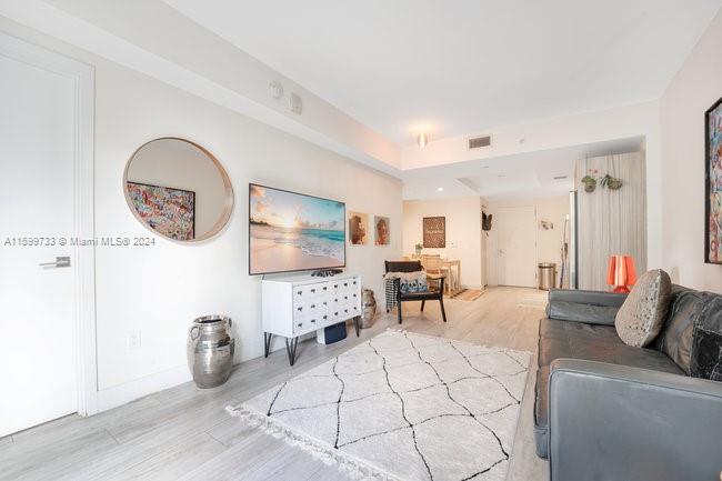 121 Northeast 34th Street, Unit L303 Miami, FL 33137 - Photo 11 of 31 a living room with furniture a flat screen tv and a table