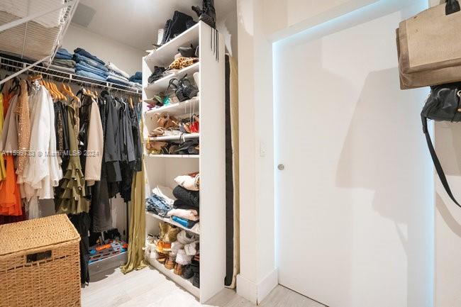 121 Northeast 34th Street, Unit L303 Miami, FL 33137 - Photo 17 of 31 a view of walk in closet with clothes and shoes