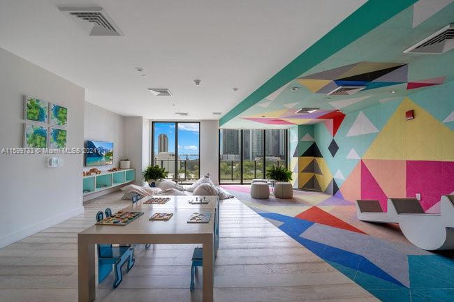 121 Northeast 34th Street, Unit L303 Miami, FL 33137 - Photo 27 of 31 a living room with patio furniture and a floor to ceiling window