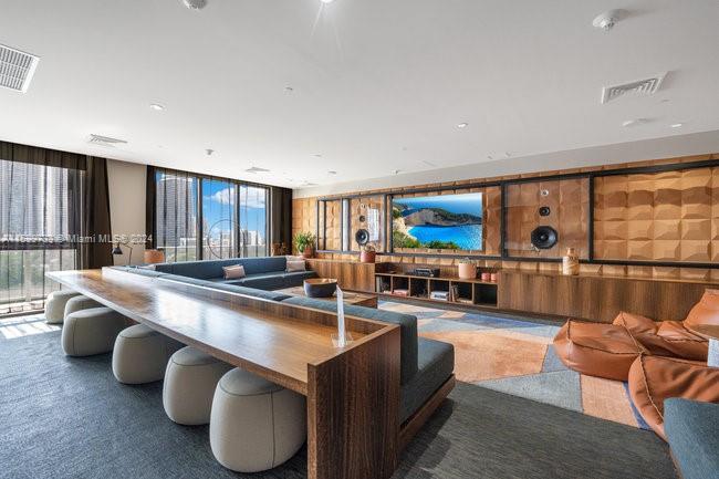 121 Northeast 34th Street, Unit L303 Miami, FL 33137 - Photo 29 of 31 a large living room with stainless steel appliances kitchen island granite countertop a couch and a flat screen tv