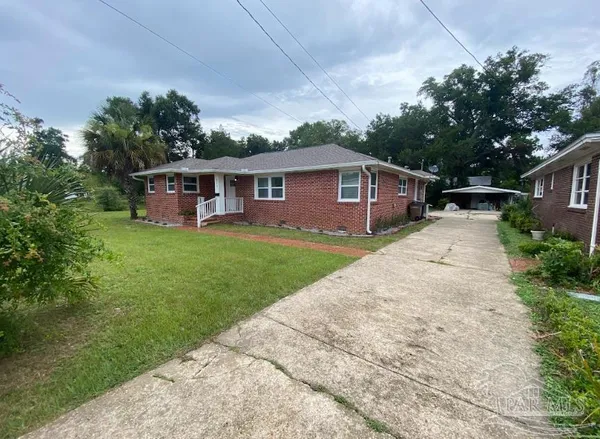 a view of a house with a yard and sitting area